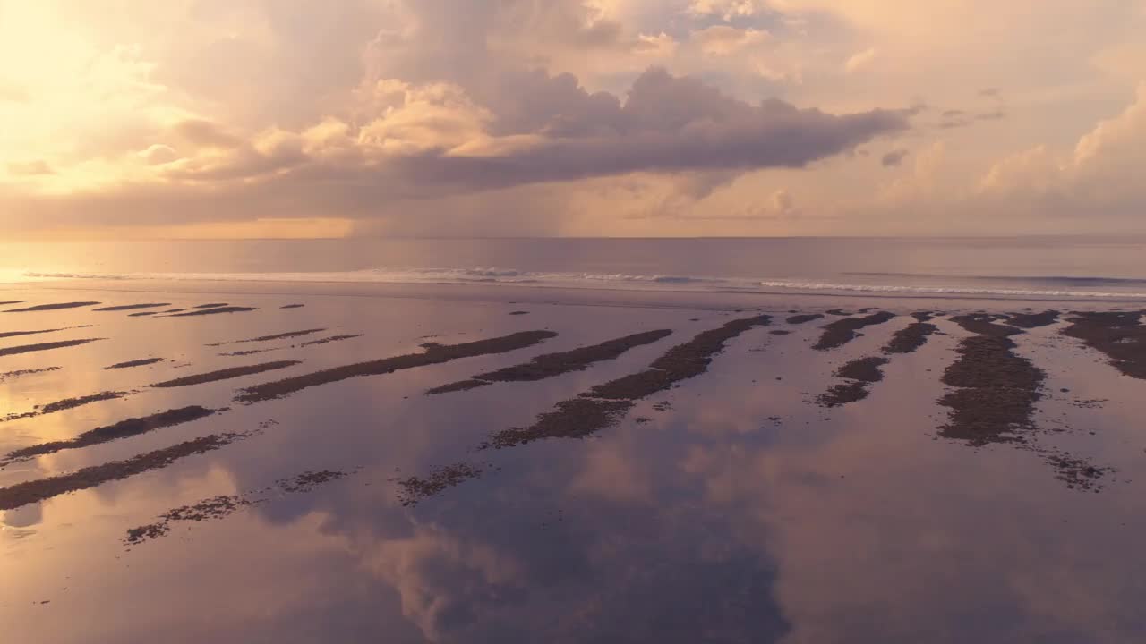 低潮时大洋海岸的日落鸟瞰图。热带无人自然宁静的水海景。电影无人机拍摄4K视频素材