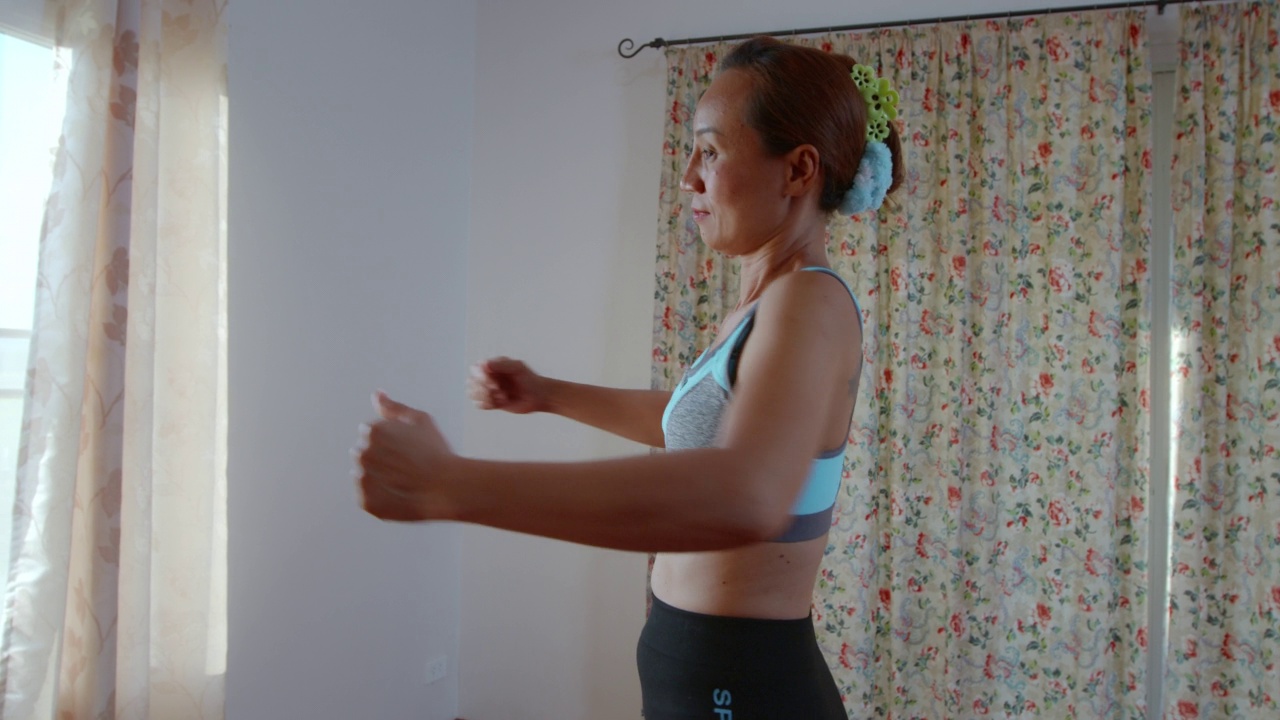 亚洲妇女做运动和伸展她的手臂来热身视频素材