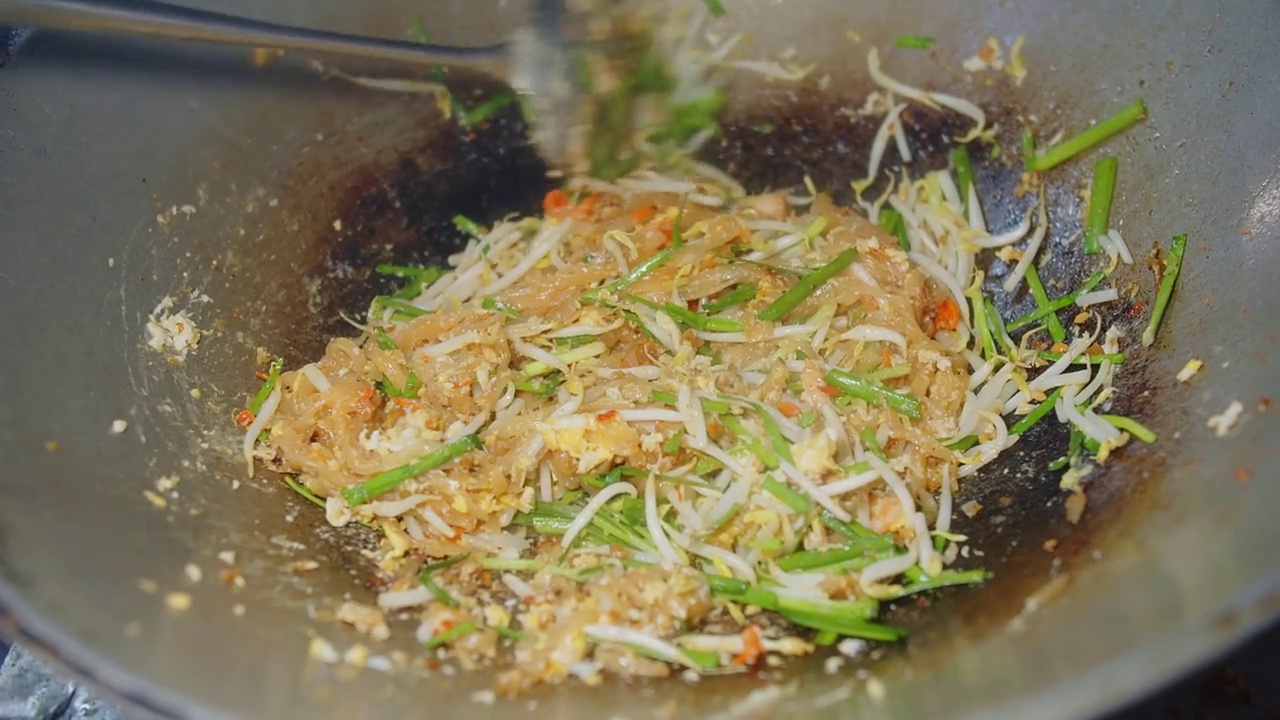 特写烹饪搅拌美味美味美味的泰式炒面或泰式炒面在泰国厨房餐厅，泰国传统受欢迎的街头小吃视频素材