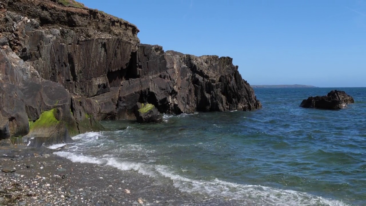 夏天的海景。多岩石的海岸。小海浪。手持视频。视频素材