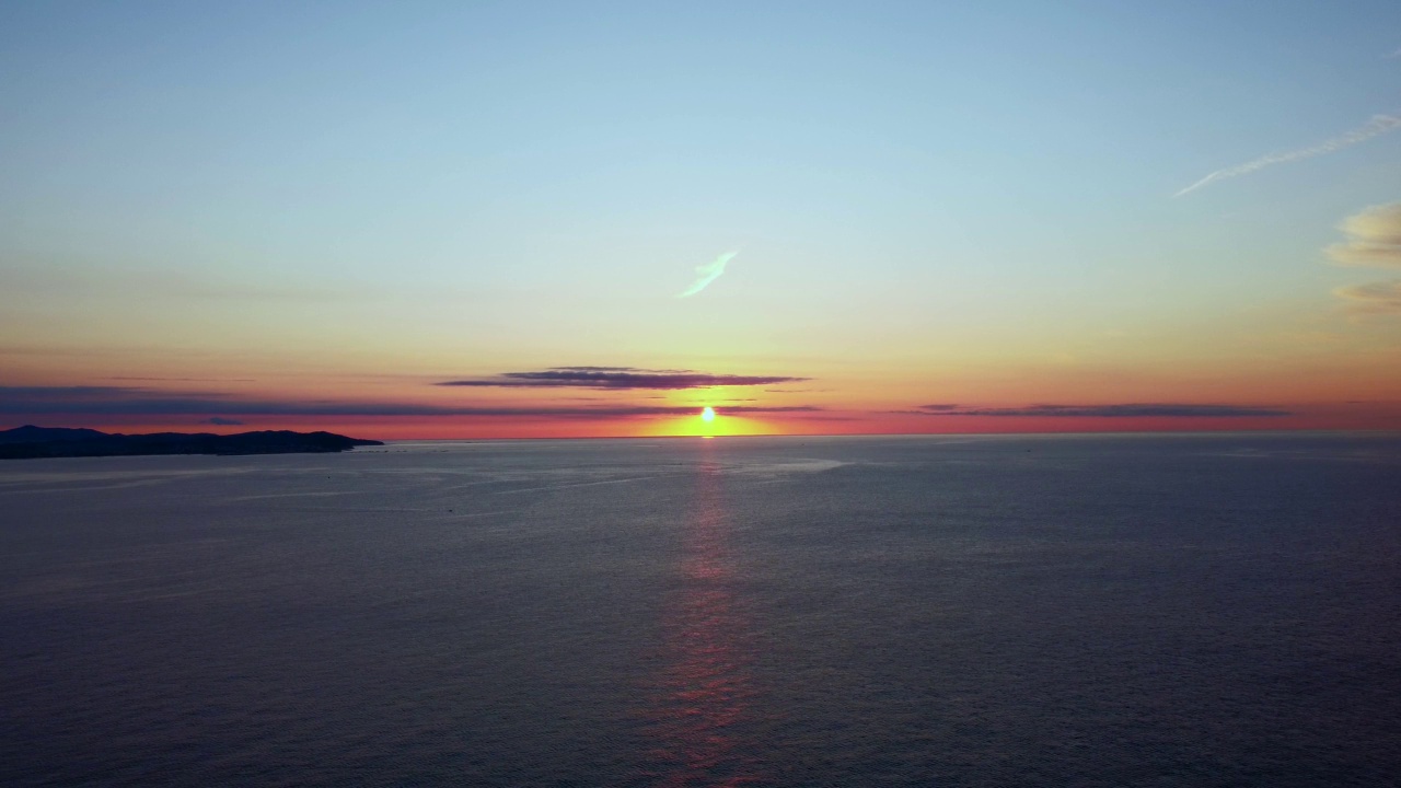 海面上明亮的日出。太阳从海上升起，开始新的一天。4k航拍海上日出暑假、假期、旅行和旅游的概念。视频素材