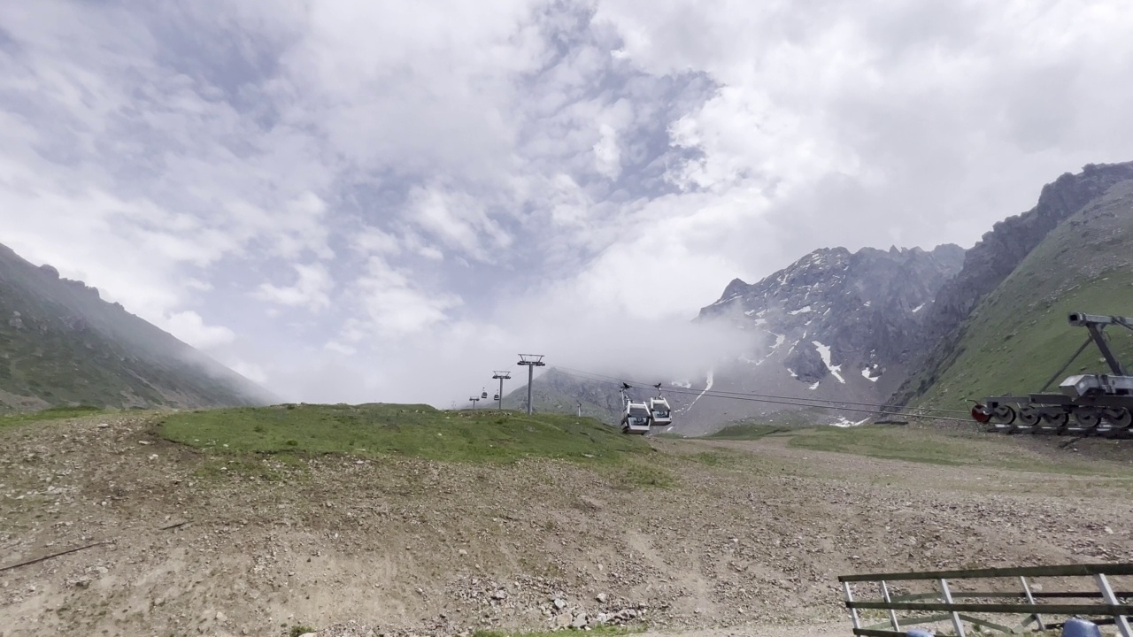 夏季的高山滑雪胜地。在山里休息。山顶上的雪。山上的索道视频下载