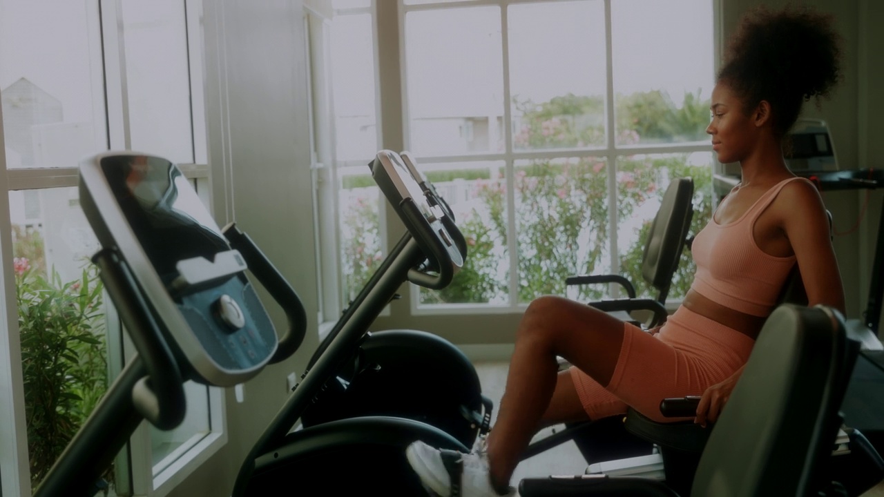 一位女士和她的朋友在健身房锻炼时聊天。视频素材