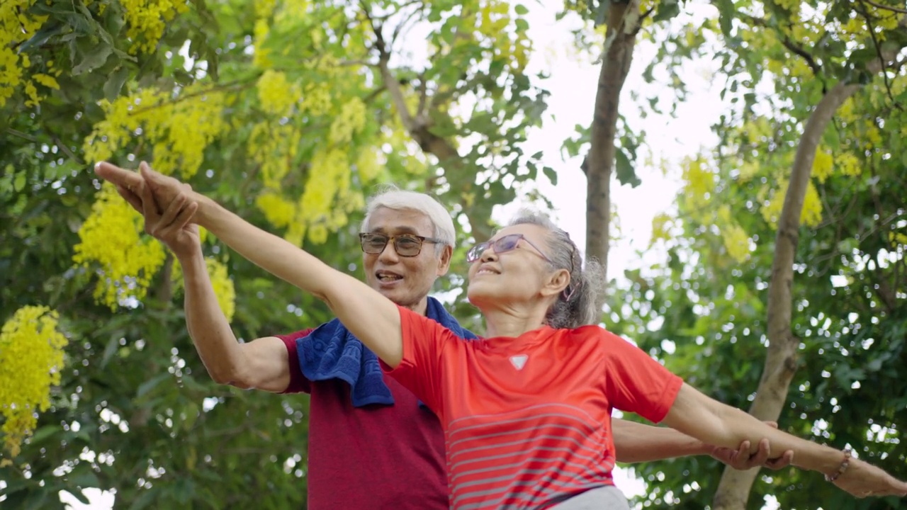 两个成年人在公园拉伸训练瑜伽视频素材