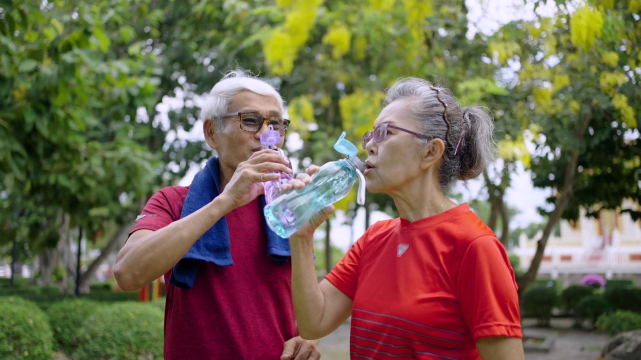 两个老年人在公园锻炼后喝水视频素材