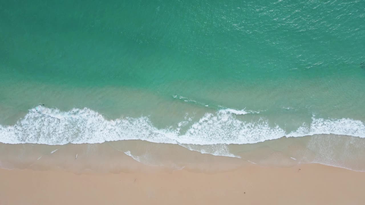 航拍视频美丽的特写镜头海滩和海水在日落时分的沙滩上的波浪(俯瞰)自然和旅游概念视频视频素材