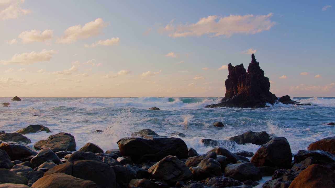 海上日落。巨浪冲击着特内里费岛的岩石、鹅卵石和火山玄武岩。水溅起水花和白色的泡沫。加那利岛,冷杉树。视频素材