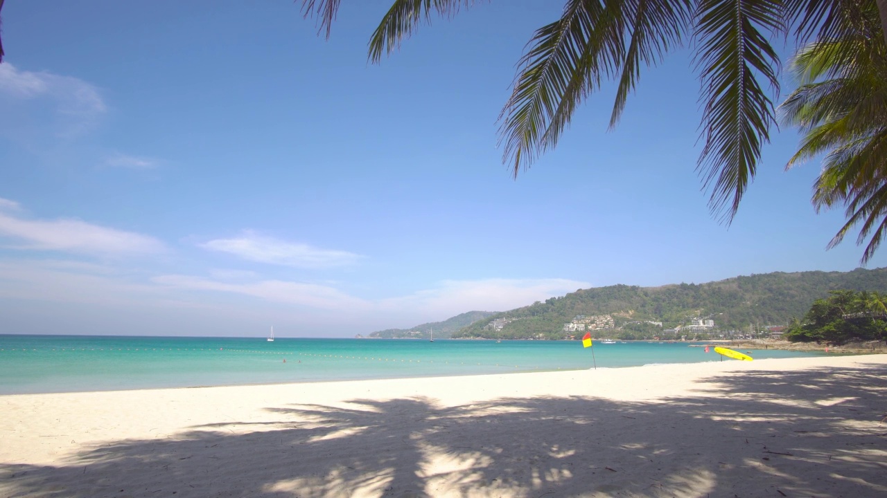 泰国普吉岛海滩海。海滩棕榈景观景观场景海滩沙滩上蓝色的海水清澈的天空清晰的背景。相机在dolly slide。在泰国普吉岛的巴东海滩。视频素材