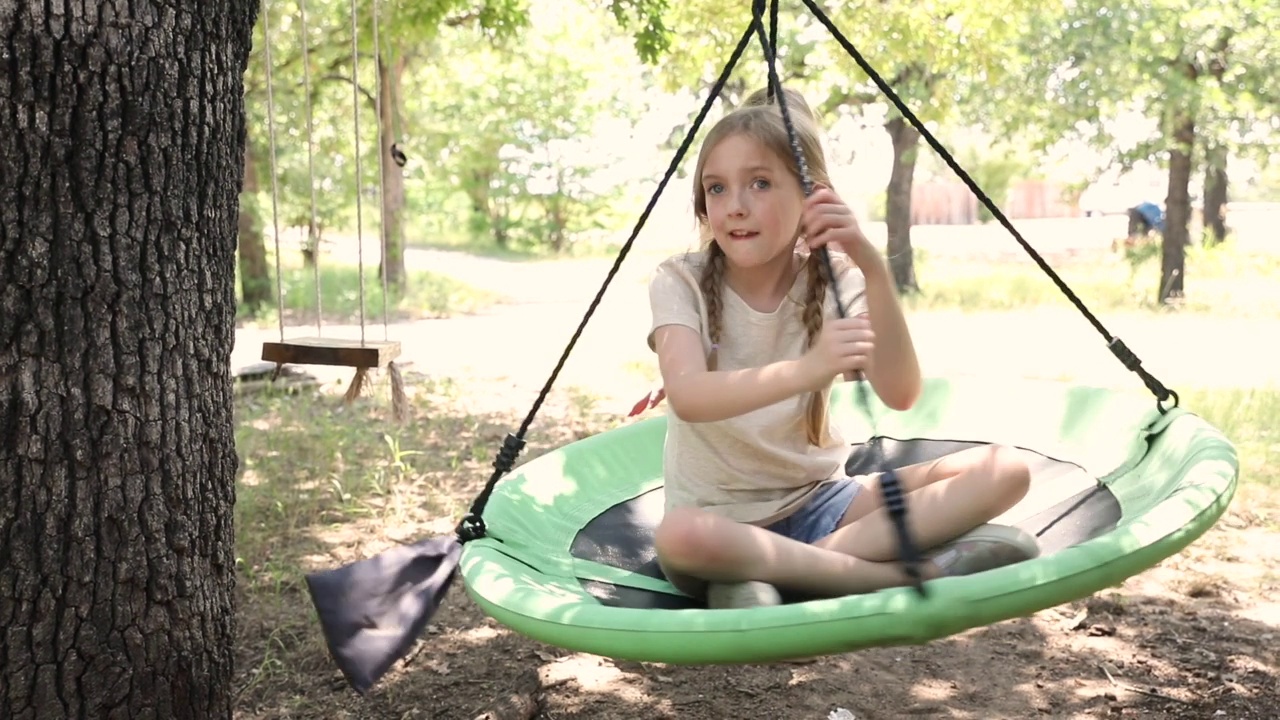 年幼的兄弟姐妹一起在户外荡秋千，欢笑着视频素材