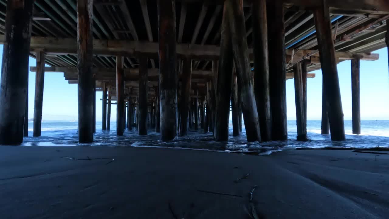 看着木柱下的码头码头，朝着海浪的海洋视频素材