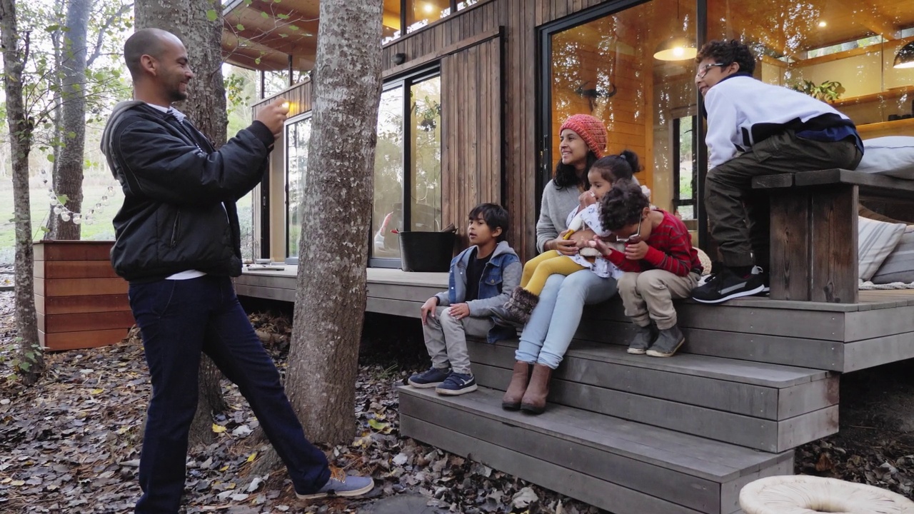 父亲在小屋的露台上给家人拍照视频素材