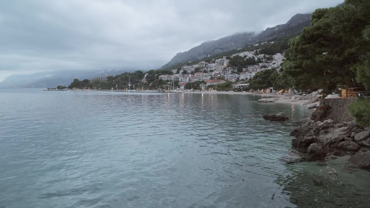 海景与一个小镇的海岸线和一座山在早上。视频素材