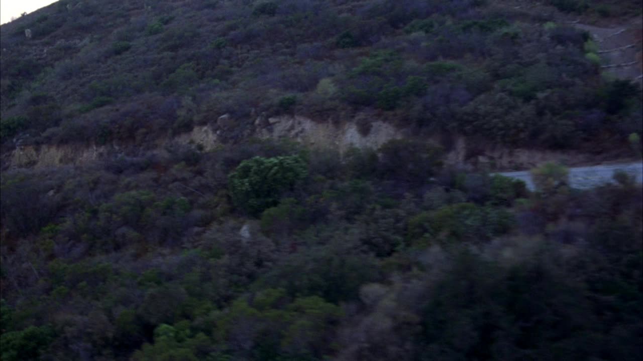 沿山路空运。波夫跟着一辆黑色豪华轿车。在bg中看到海洋和海岸视频素材