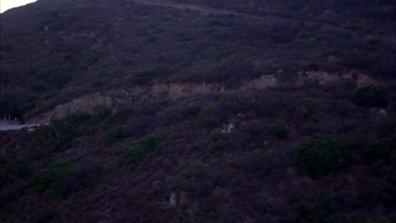 沿山路空运。波夫跟着一辆黑色豪华轿车。在bg中看到海洋和海岸视频素材