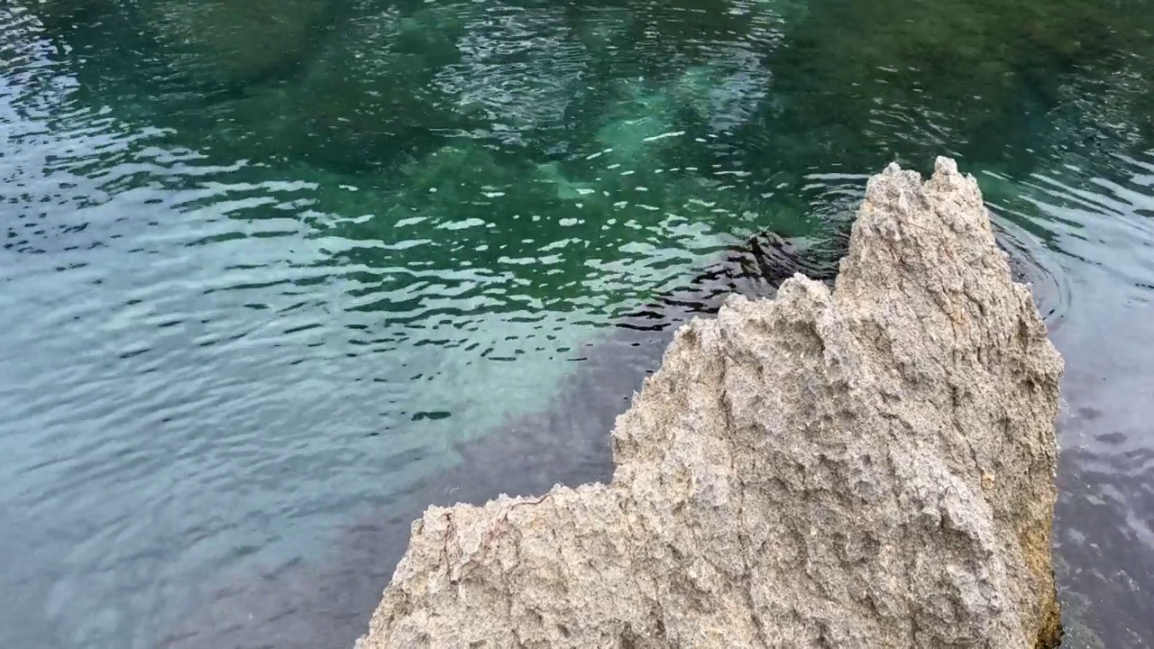 海岸岩石和蓝绿色清澈的海水。视频素材