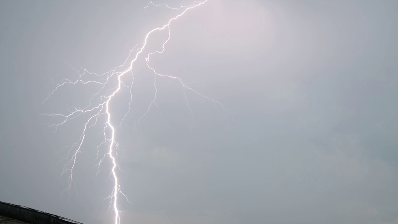 一组美丽的闪电击中城市，高清股票视频的真正的闪电和雨滴在树叶，和多云的天空。视频素材