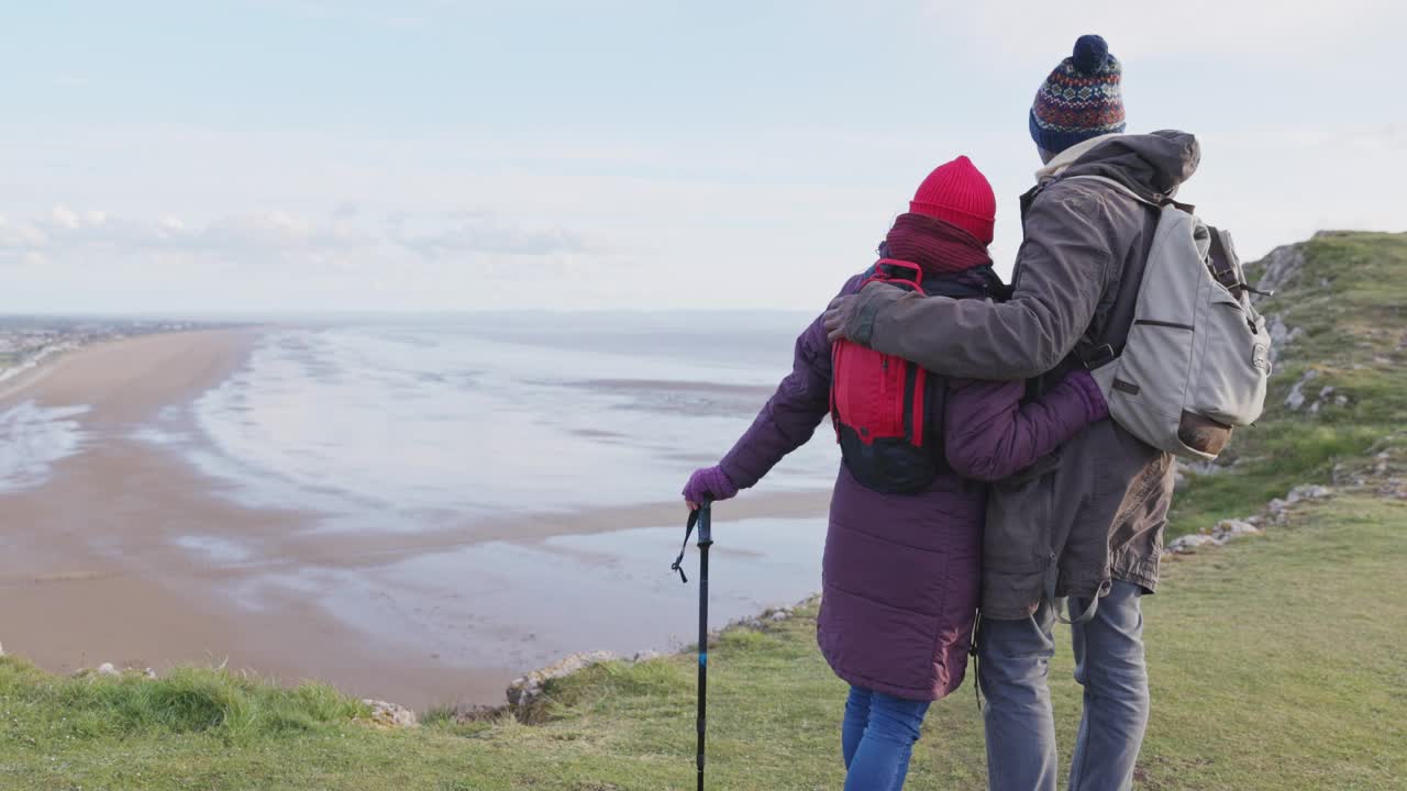 深情的情侣徒步旅行，享受着英国多塞特郡的海滩海景视频素材