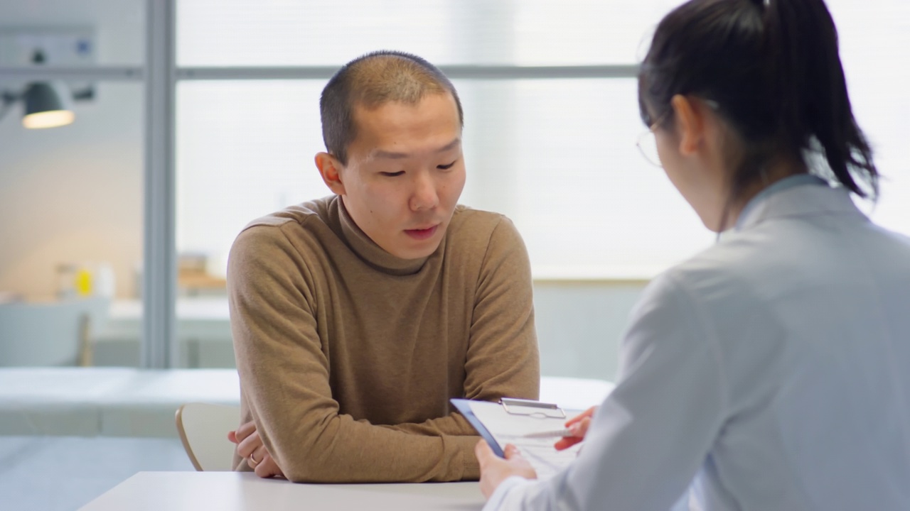 亚洲男子在医务室看医生视频素材