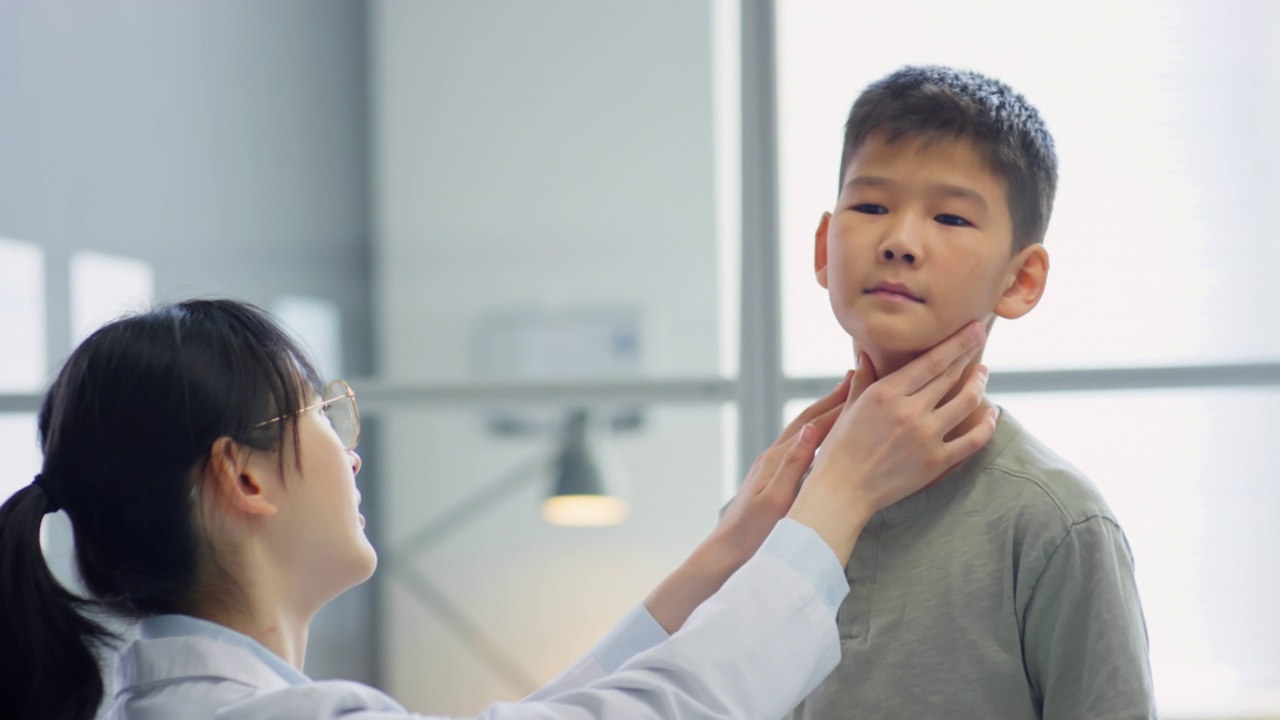 女医生检查亚洲男孩的脖子视频素材