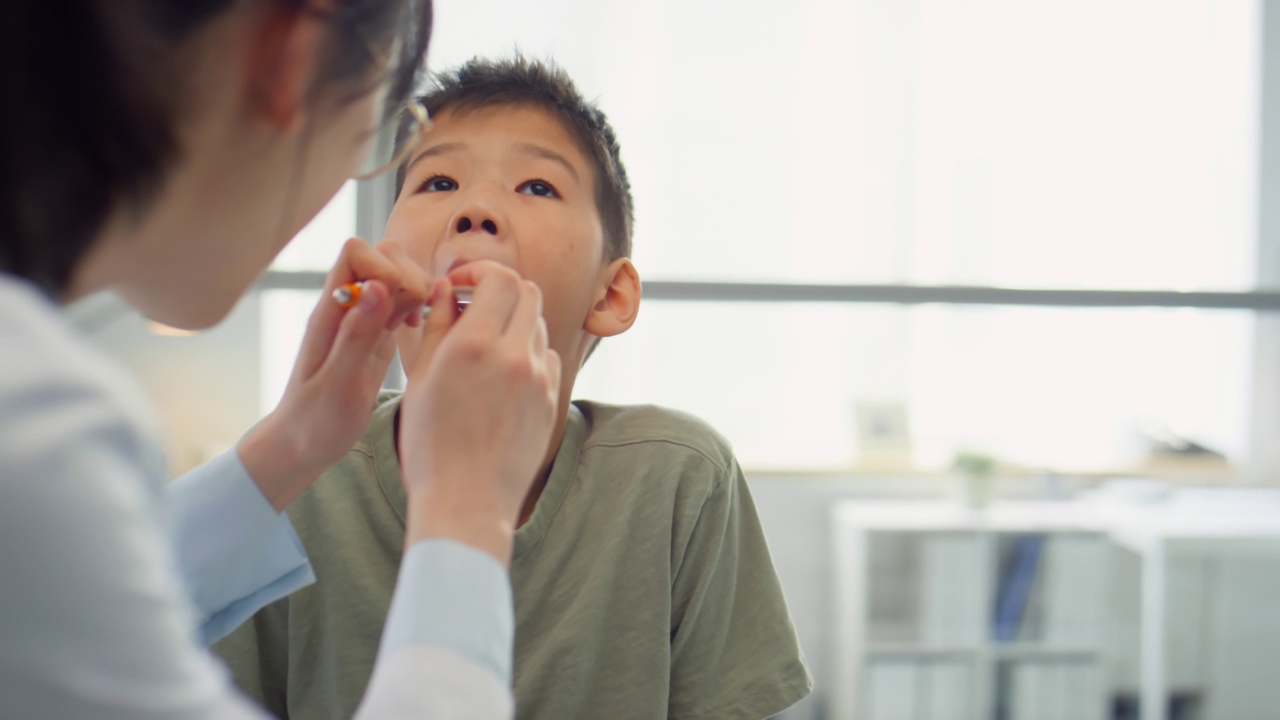 耳鼻喉科医生检查亚洲男孩的喉咙视频素材