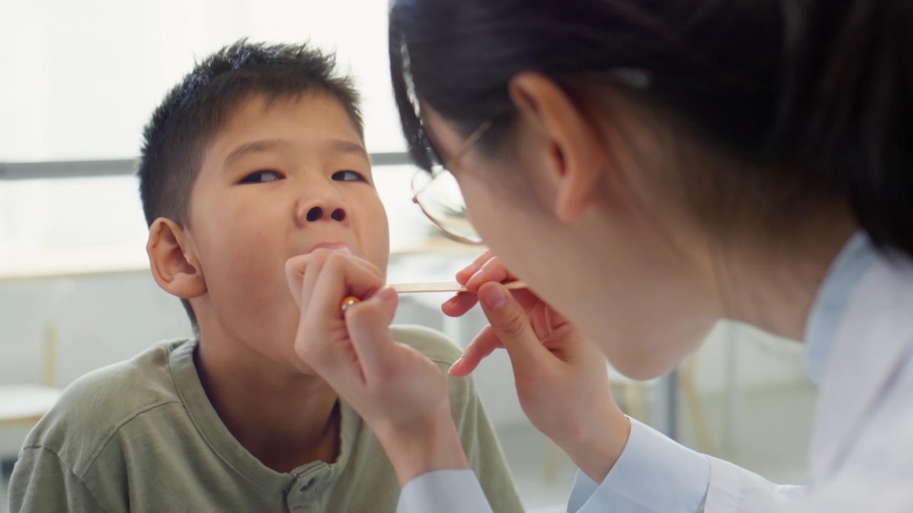 医生检查亚洲男孩的喉咙视频素材