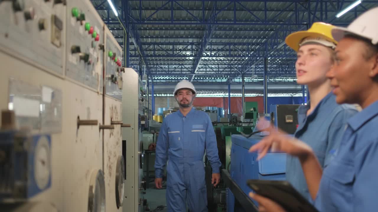 工业工程师团队在制造工厂检查机器控制面板。视频素材