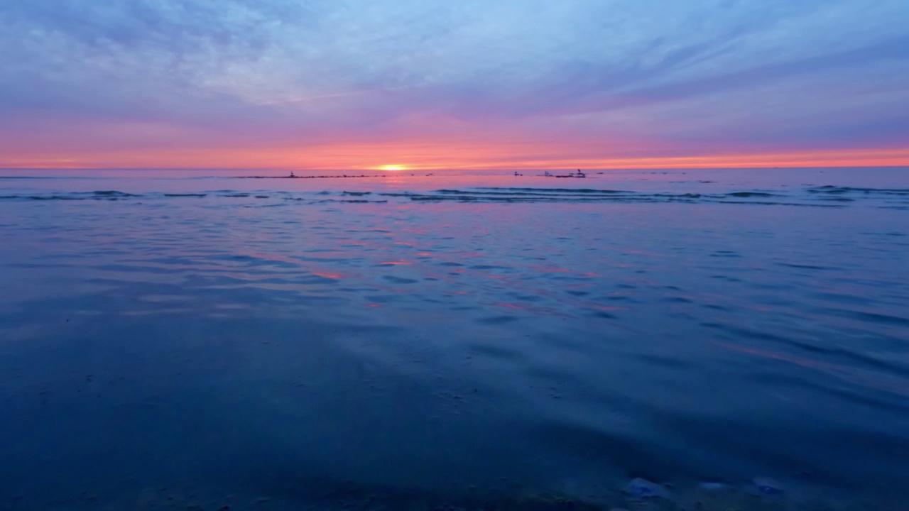 海滩上的日落，缓慢移动的波浪和温暖的夏天的光。没有人的慢动作视频。视频下载