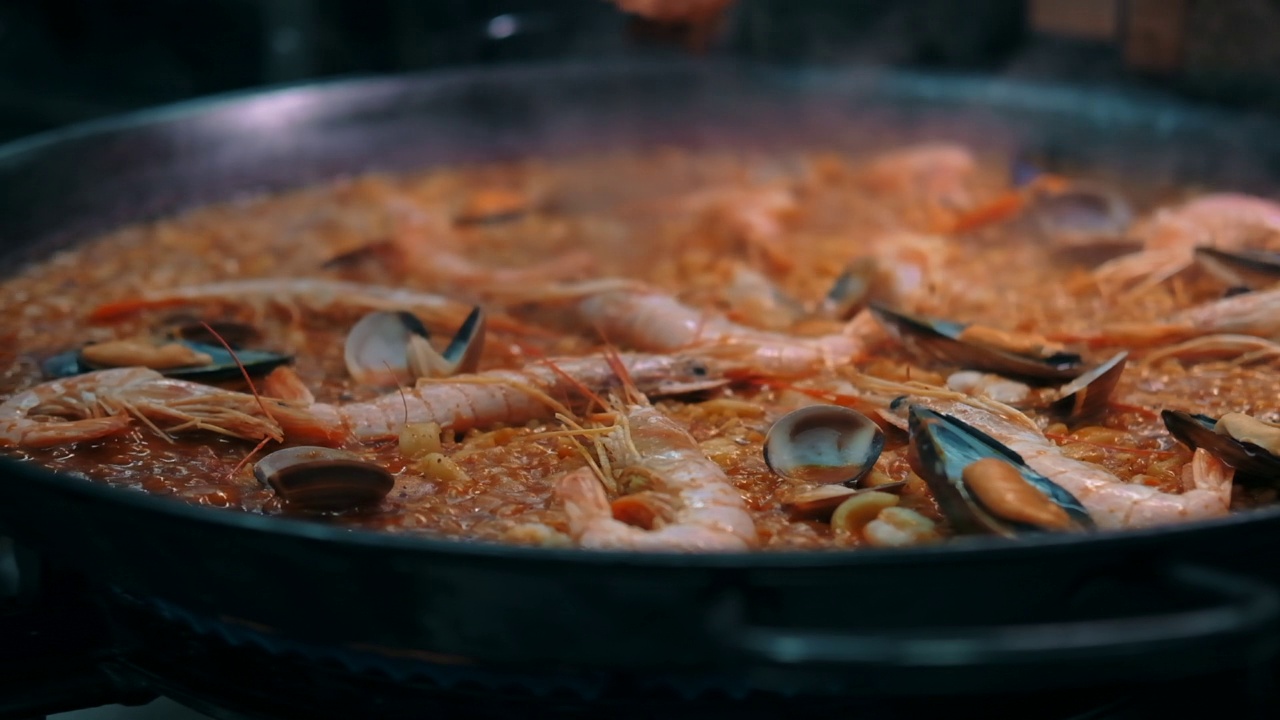 特写慢动作查看海鲜饭在煎锅上烹饪视频素材