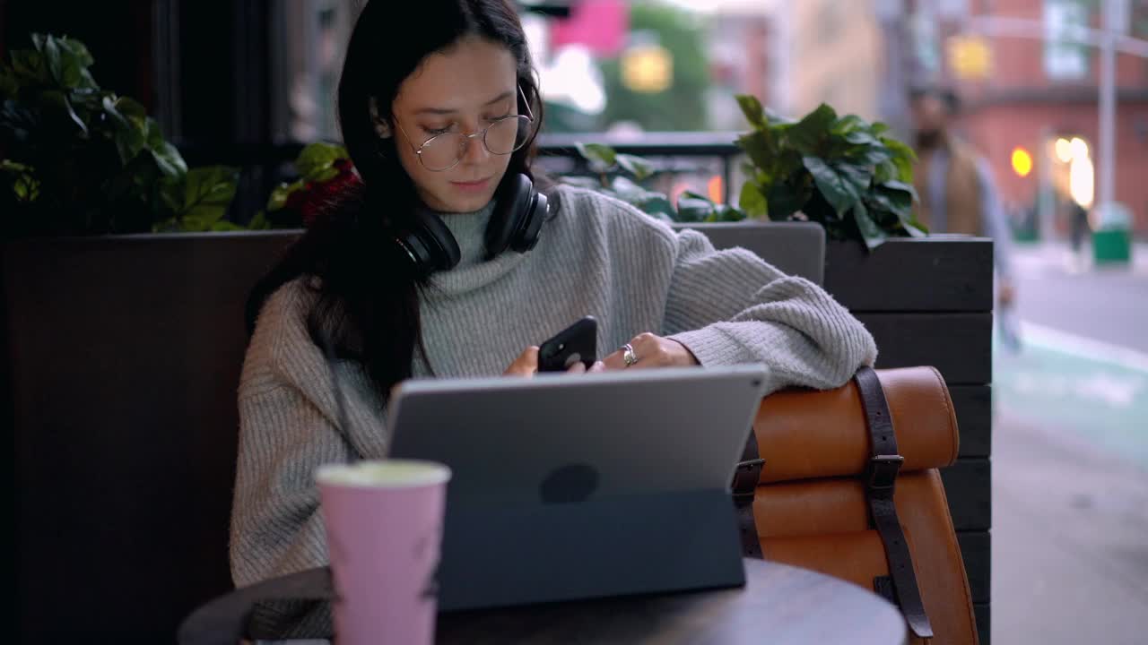 戴着矫正视力的经典眼镜的千禧一代女性在社交网站上花时间打电话视频素材