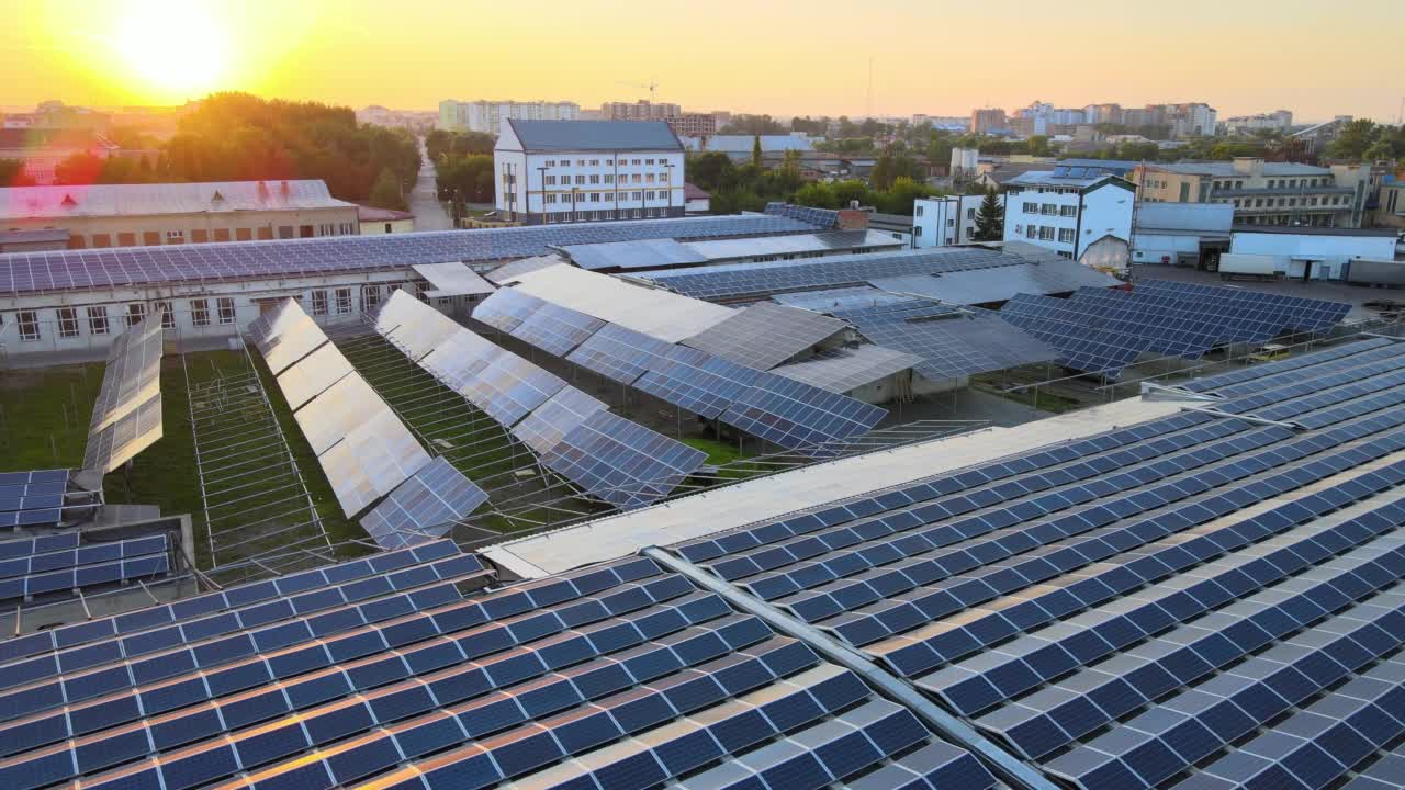 太阳能发电站鸟瞰图，蓝色光伏板安装在工业建筑屋顶，晚上生产绿色生态电力。生产可持续能源的理念视频素材