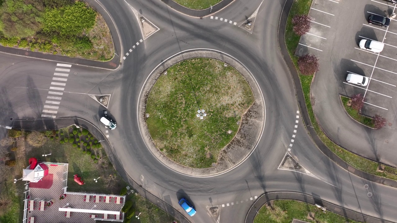 快速移动的繁忙交通的道路回旋交叉路口鸟瞰图。城市环形交通十字路口视频素材