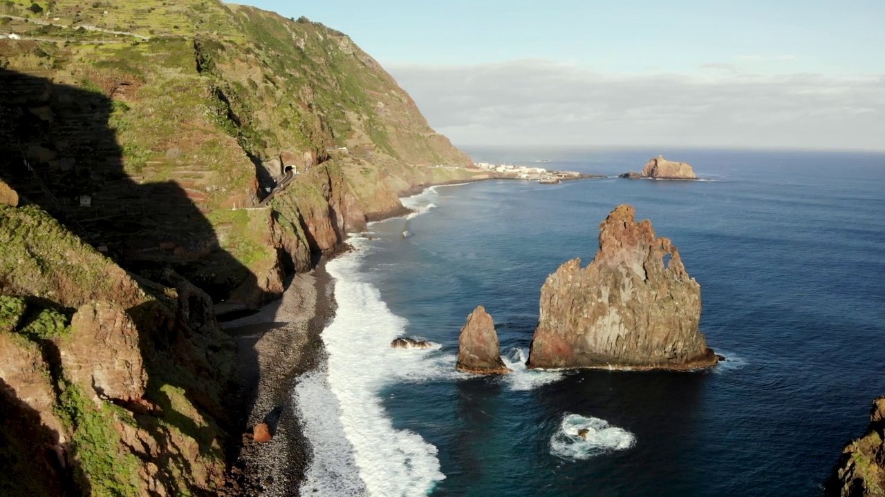 海浪冲击岩石海滩和山脉海岸线视频素材