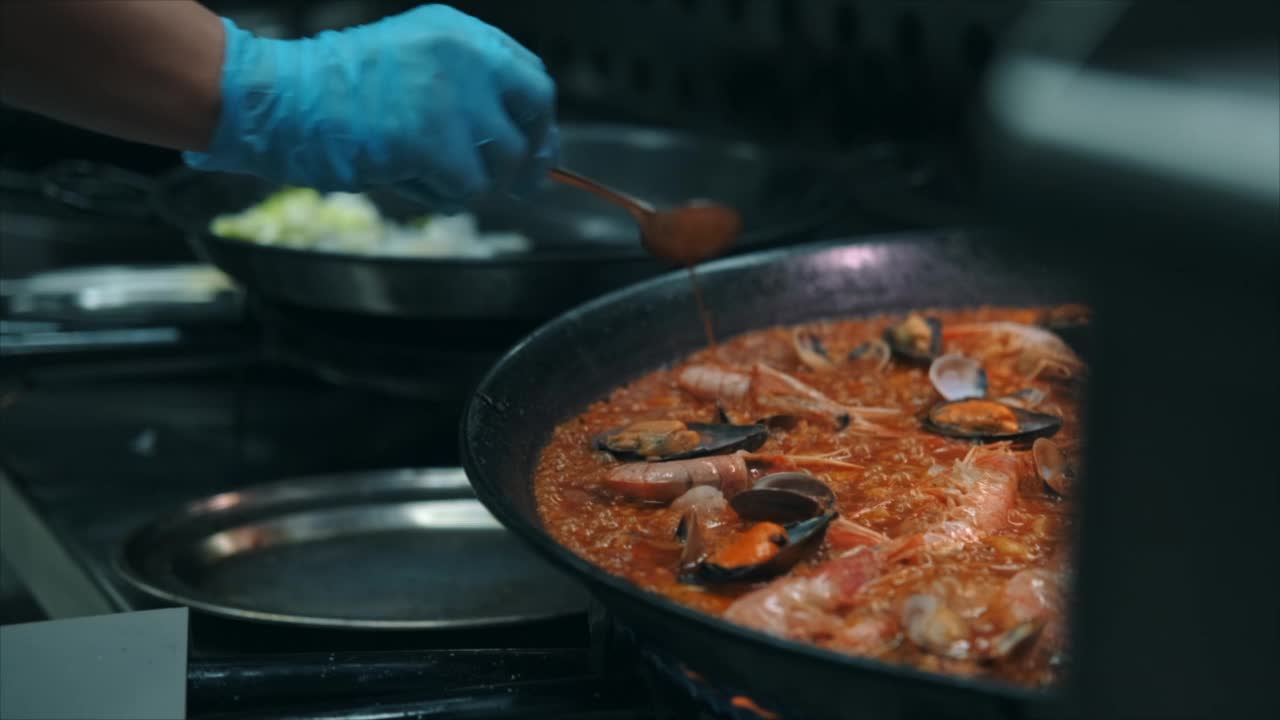 特写慢动作查看海鲜饭在煎锅上烹饪视频素材