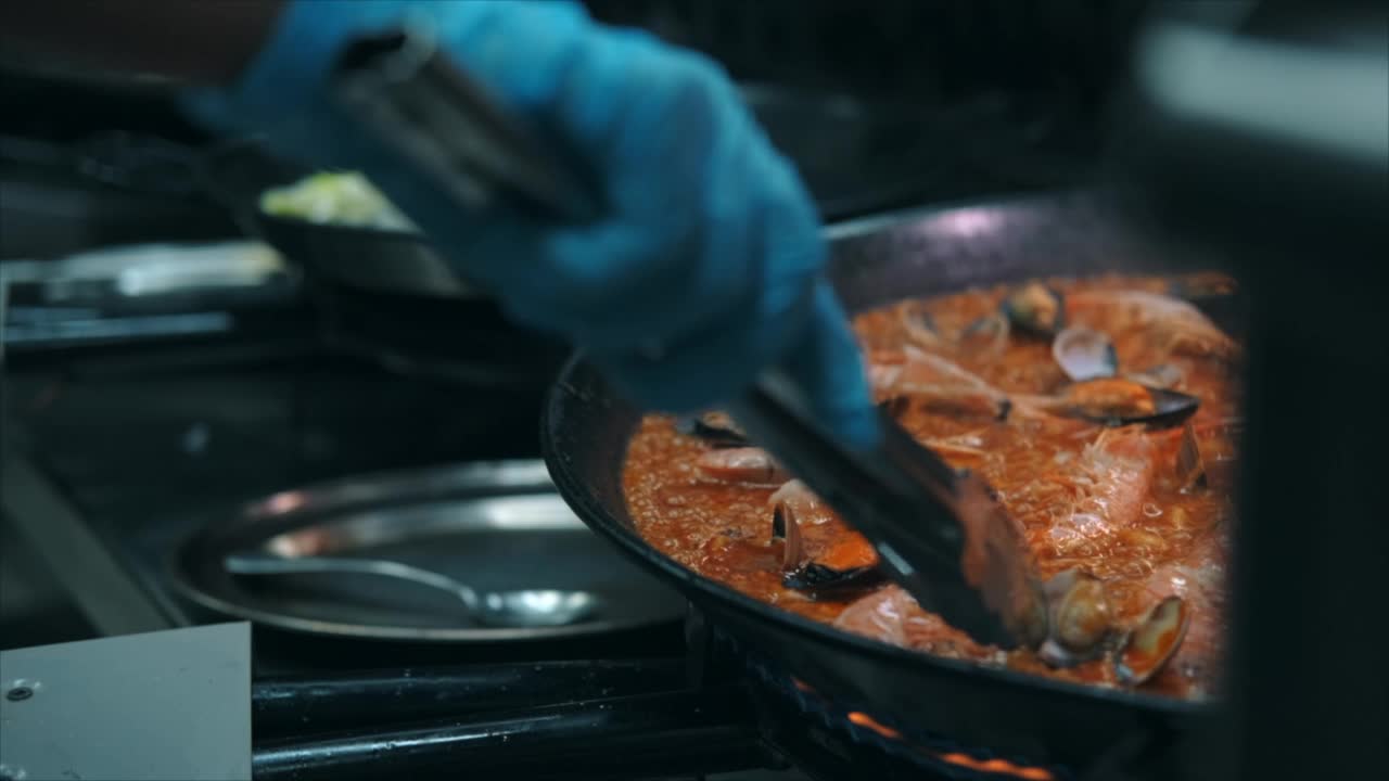 特写慢动作查看海鲜饭在煎锅上烹饪视频素材