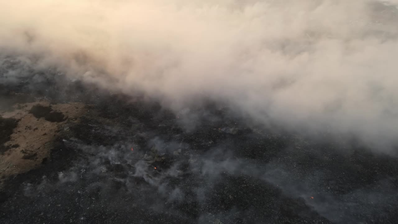 空中旋转观察垃圾堆燃烧和释放有毒烟雾视频素材