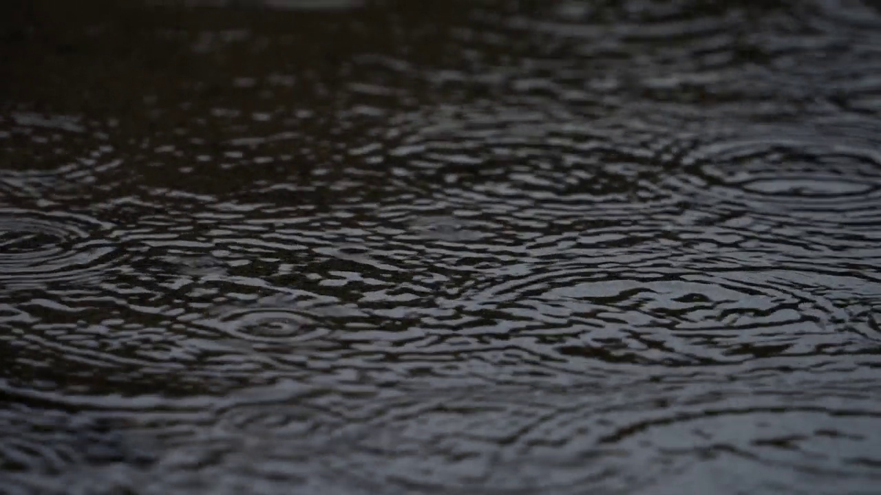 4K慢动作视频，下雨天的水坑上泛起阵阵涟漪。视频素材