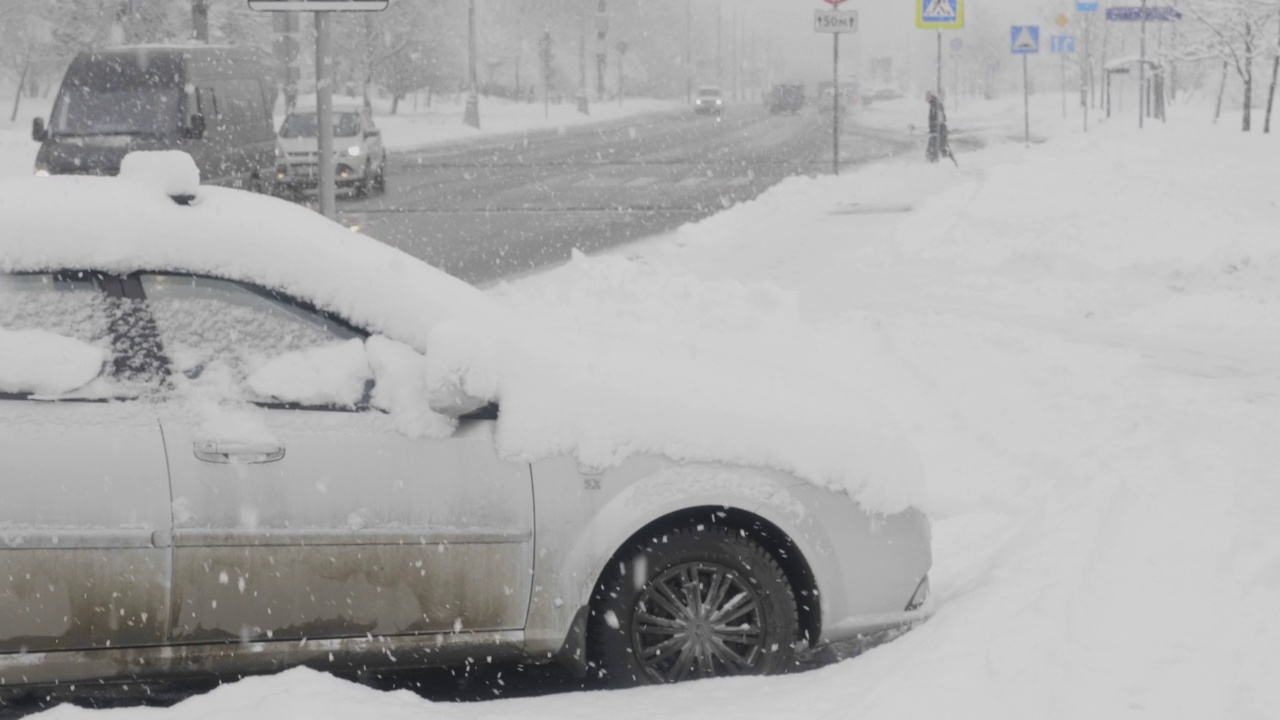 雪在城市的道路上与汽车。视频素材