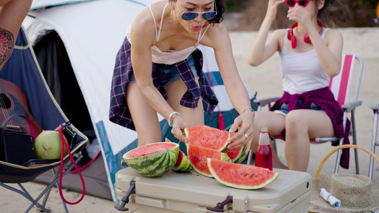 一群亚洲朋友在夏天享受海滩野餐和露营视频素材