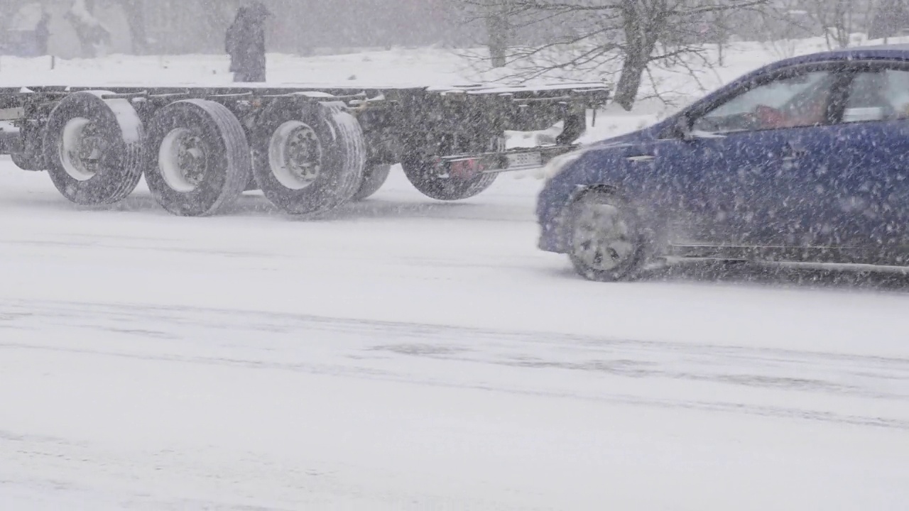 雪在城市的道路上与汽车。视频素材