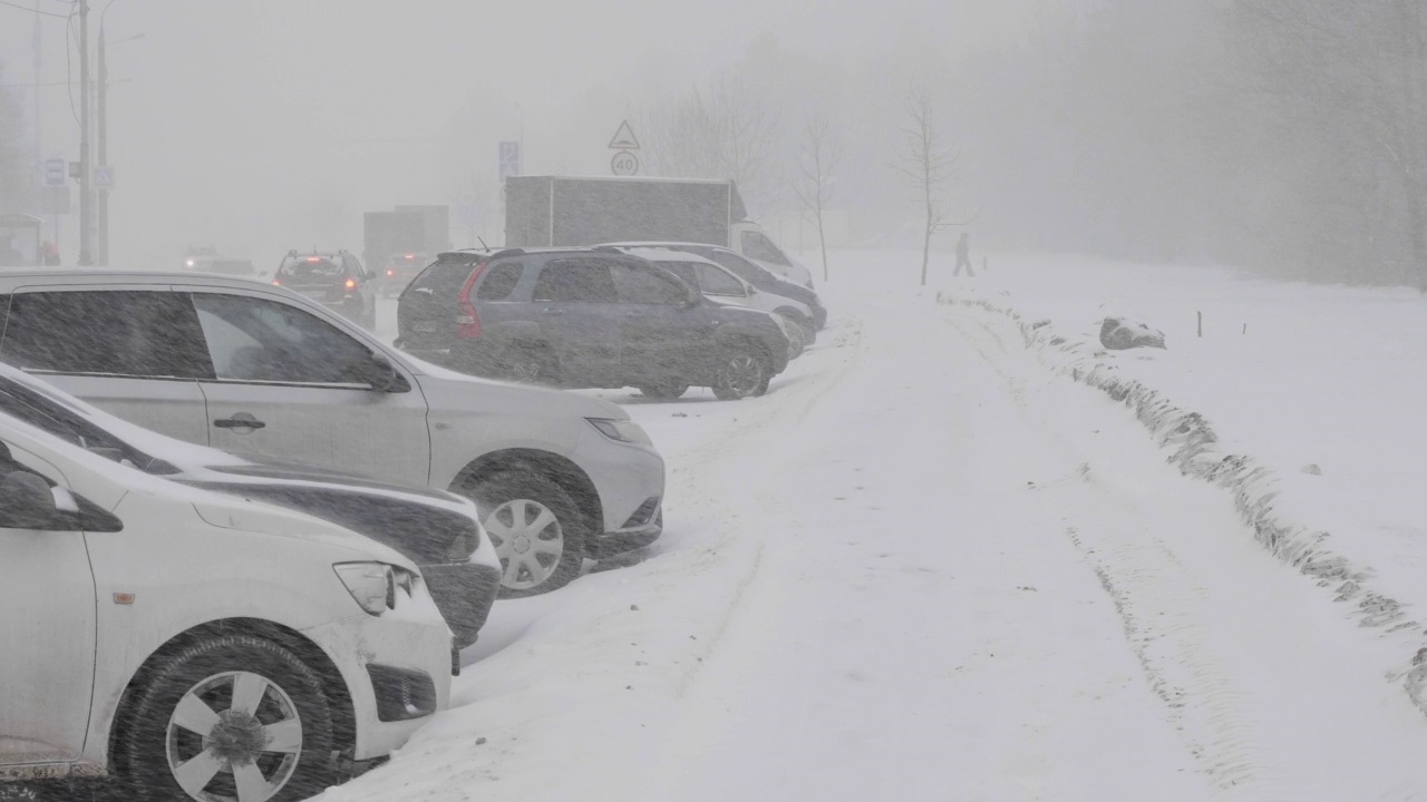 雪在城市的道路上与汽车。视频素材