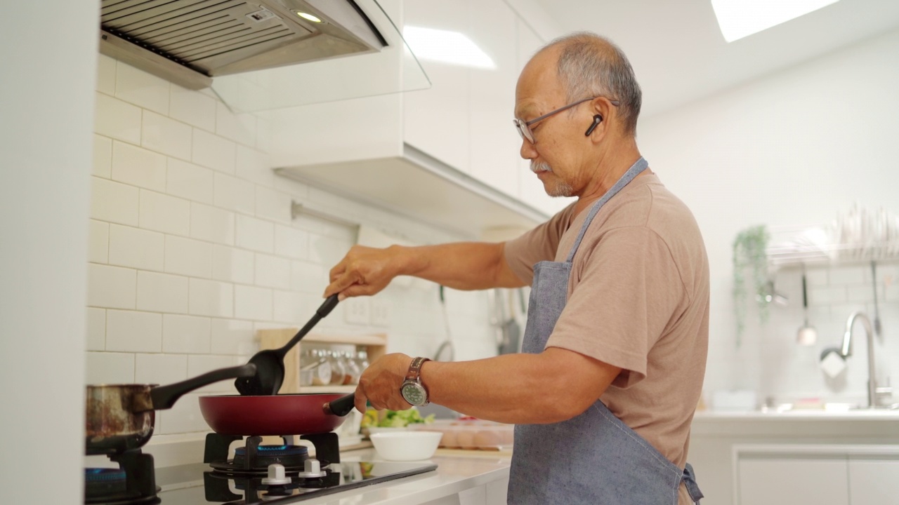 亚洲男子在厨房做饭视频素材