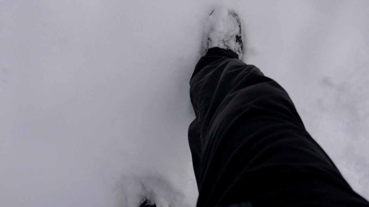 一个人在冬天的雪地里行走的俯视图。视频素材