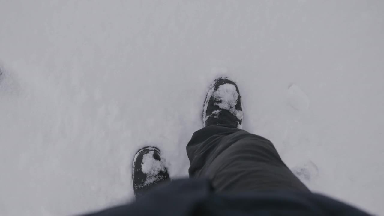 一个人在冬天的雪地里行走的俯视图。视频素材