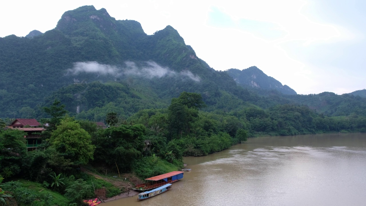 在雾天的山景与房子和船在南欧河，老挝Nong Khiaw视频素材