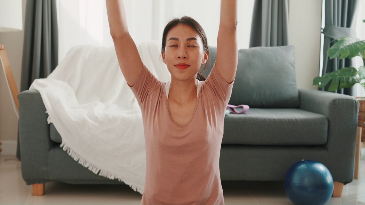 年轻迷人的强壮美丽的健身女孩亚洲女子在家里的客厅练习做锻炼初学者。视频素材