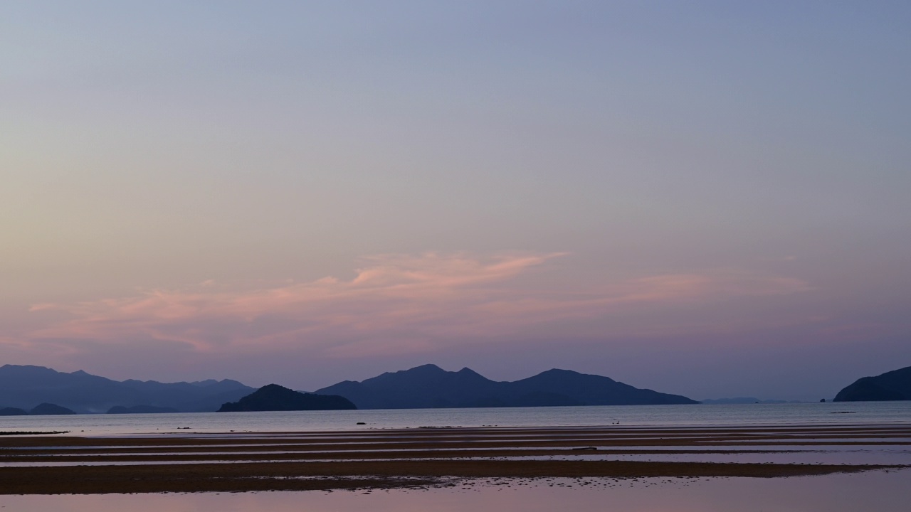 彩色的日落在海岛海滩与海浪和反射的天空。视频素材