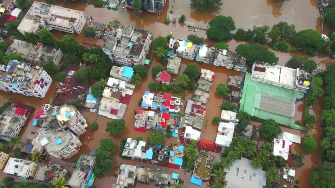 大城市的鸟瞰图被洪水和降雨淹没。房子满溢泥泞的水自然灾害的概念，气候变化和破坏。视频素材