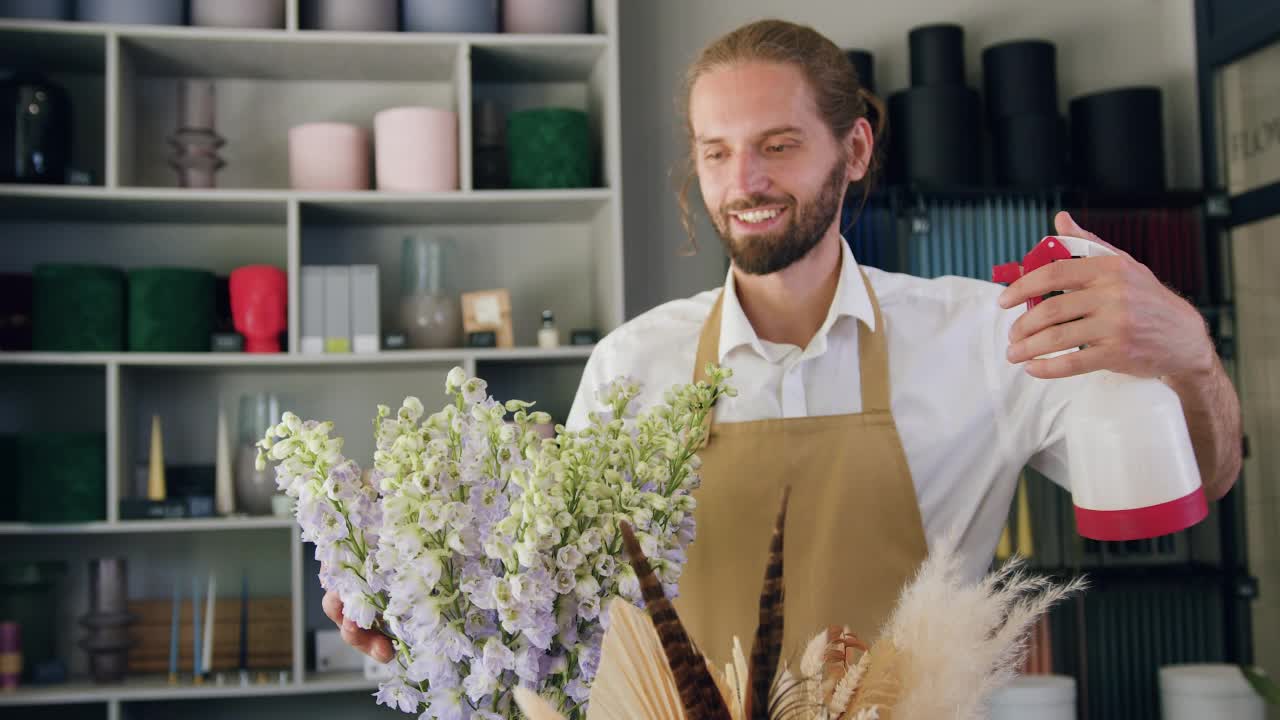 在花店工作的花商。专业花匠和花匠在自己的花店为鲜花浇水，照顾树叶，控制水分质量视频素材