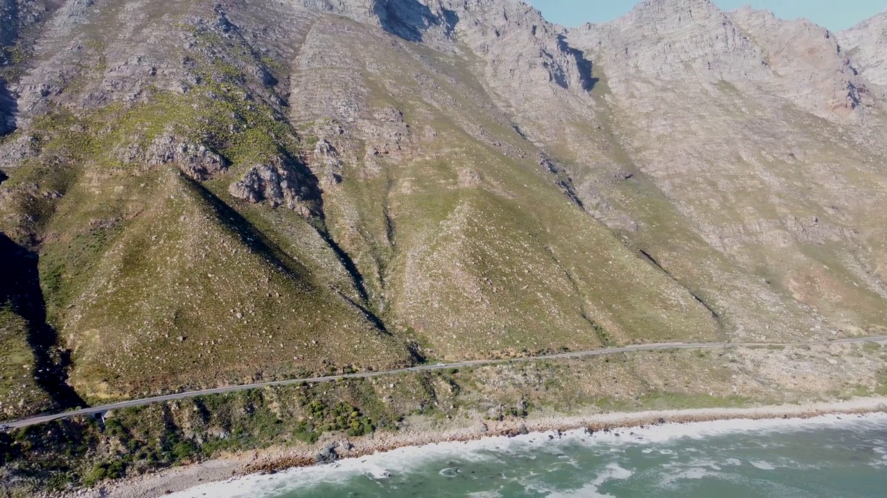 鸟瞰图平移下一个薄柏油路运行下面的绿山相机的道路视频素材