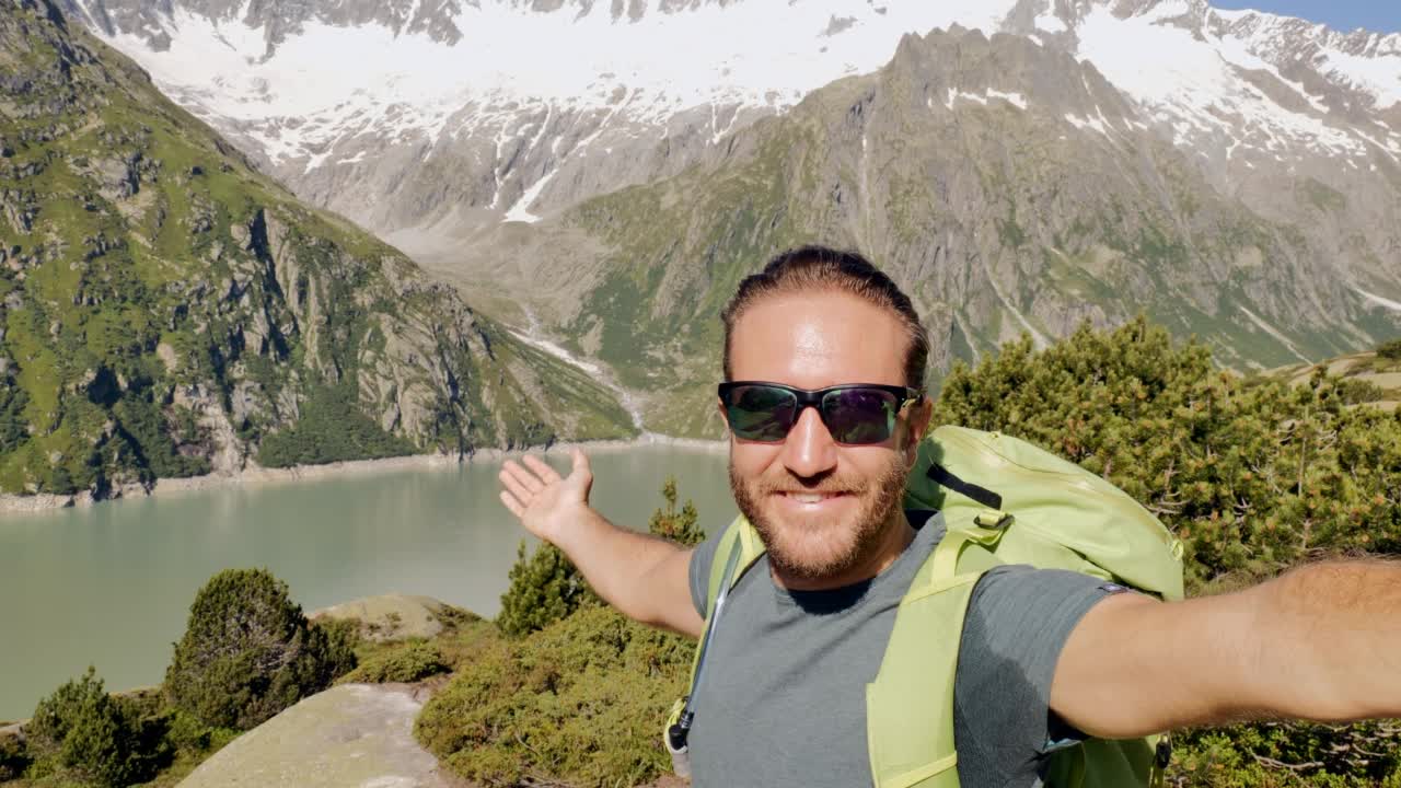 男性徒步旅行者在美丽的风景前自拍视频素材